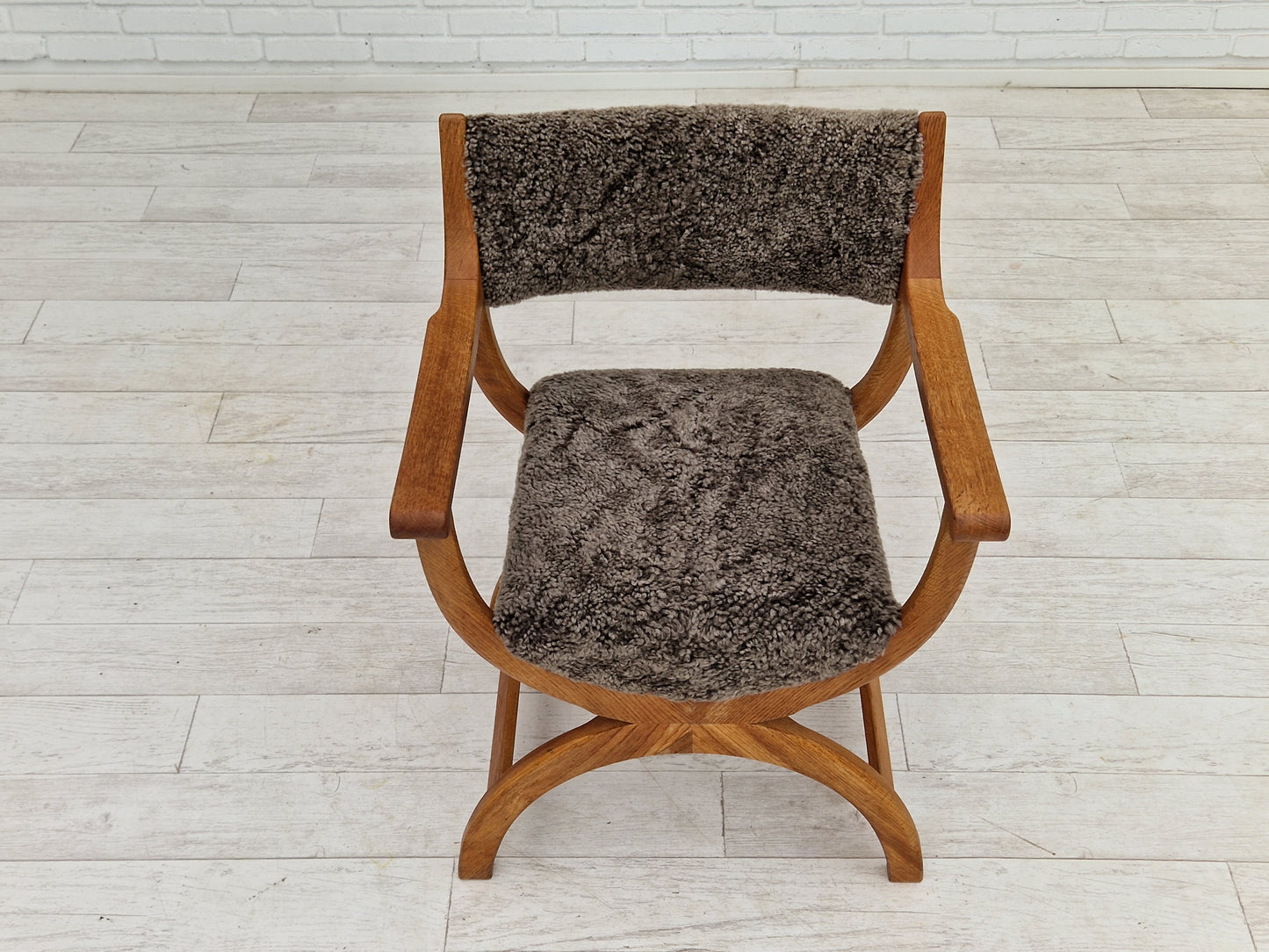 1960s, Danish design by Henning Kjærnulf, chair model "Kurul", sheepskin, oak wood.