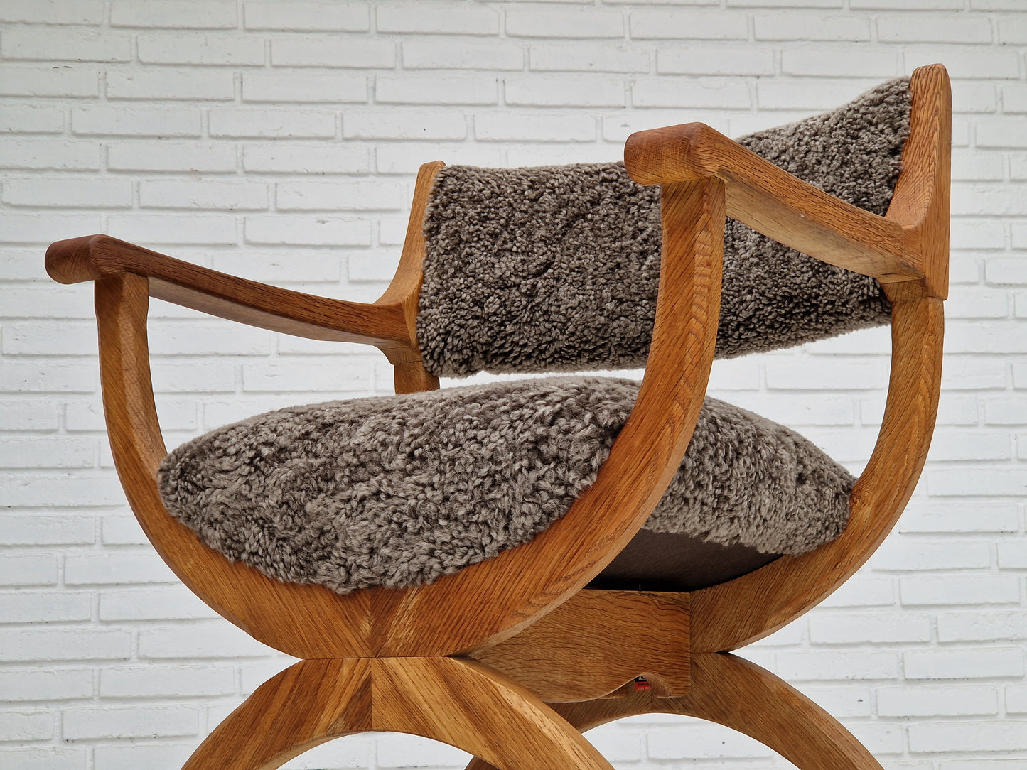 1960s, Danish design by Henning Kjærnulf, chair model "Kurul", sheepskin, oak wood.